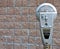 Retro parking meter with brick background