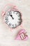 Retro pink clock and soft pink heart with word WISH on wooden ba