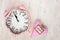 Retro pink clock and soft pink heart with word WISH on wooden ba