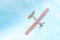 Retro plane with propeller flying and dives against the blue sky