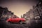 Retro red car on cobblestone historic old town in rain. Wroclaw, Poland.