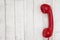 Retro red phone handset on weathered whitewash textured wood background