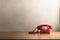 Retro Red Telephone on Light Wood Veneer Desk