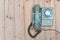 Retro rotary telephone with cable on wood table, wooden background, top view with copy space, vintage communication concept