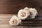 Retro still life with vintage rose flowers and ancient book. Nostalgic composition on old wooden table.