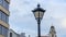 Retro street lamp. Vintage lamppost near the old church on dramatic sky background