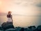 Retro style of lonely and depressed woman sitting in front of the sea in a deserted beach.