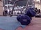 Retro style of a pair of small blue dumbbells of 2 kilograms placed on rubber gym floor with different gym interior equipment