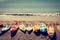 Retro style photo of colourful kayaks lined up on a sandy beach. Toned image