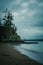 Retro style photo of a rocky cliff at the edge of a sandy beach on a stormy evening