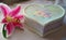 Retro style set bouquet of pink lily flower and handmade craft gift box in form of heart on natural color tablecloth board,