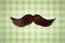 Retro styled image of a moustache in front of green wallpaper