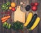 Retro styled vintage food background. Fresh vegetables and ingredients for cooking around cutting board on rustic weathered wood