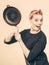 Retro styled woman having fun with kitchen accessories.