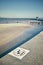 Retro stylized no diving sign on a pier with shallow water in ba