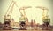 Retro stylized picture of cranes in Szczecin City.