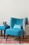 Retro teal armchair and matching ottoman with decor objects