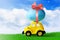 Retro toy car with Easter egg on the roof on spring background. Easter concept