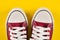 Retro Vibes: Red Sneakers on Yellow Background - Fashion and Style Revival