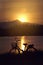 Retro vintage bicycle near the lake at sunset moment. silhouette bicycle at the sunset with grass field.big mountain and sunset
