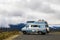 Retro vintage blue and white camper van sits at overlook for misty Northern California mountains