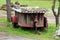 Retro vintage homemade tractor trailer with metal and wooden boards frame left in muddy backyard covered with sheet metal