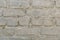 Retro whitewashed old brick wall surface. White rustic texture. Vintage structure. Grungy shabby uneven painted plaster