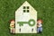 Retro wooden board for hanging keys and boy and girl dolls on green grass