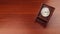 Retro wooden clock. square shaped vintage clock with round dial. wood table