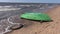 Retro wooden green boat on empty sea resort beach