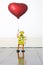 Retro yellow robot toy holding a red balloon