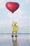 Retro yellow robot toy holding a red balloon