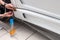 Retrofitting the car with a solid transparent protective film, the master smooths the surface by squeezing air bubbles with a