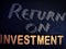 return on investment word displayed on chalkboard concept with wooden alphabet texture