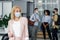 Return to work after lockdown and new normal. Woman in protective mask looks to the side in corridor of modern office