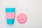 Reusable blue cup with pink silicone sleeve and lid for coffee, hot and cold drinks