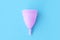 Reusable menstrual cup on blue background. Women health concept, intimate hygiene, alternative means hygiene. Zero waste. Flat lay