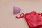 Reusable pastel purple menstrual cup on a pink background. Eco-friendly way of women's hygiene, menstruation, critical