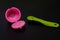 Reusable pink coffee capsule beside a spoon .