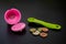 Reusable pink coffee capsule with spoon & euro coins.