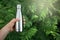 Reusable stainless thermos bottle for water in female hand to replenish the body`s water reserves against the background of fern