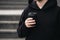 Reusable stylish bamboo black cup in the hands of a man, close-up.