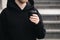 Reusable stylish bamboo black cup in the hands of a man, close-up.