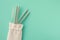 Reusable stylish eco friendly sustainable stainless steel metal straws on light blue background.