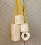 Reusable thread mesh filled with rolls of toilet paper hanging on the pantry door. Home storage for future use