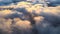 Reveal footage of aerial view from above at high altitude of dense puffy cumulus clouds flying in evening. Amazing