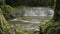 Reveal lifting shot fresh water rapids flows into the natural pond under sunshine in the jungle.