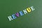 REVENUE word on green background composed from colorful abc alphabet block wooden letters, copy space for ad text