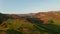 Reverse drone view of smooth orange scenery mountain highlands in Iceland. Aerial birds eye view of red volcanic