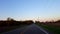 Reverse motion driving rural countryside road during sunset backward time lapse. Driver point of view POV while sun rises on ho